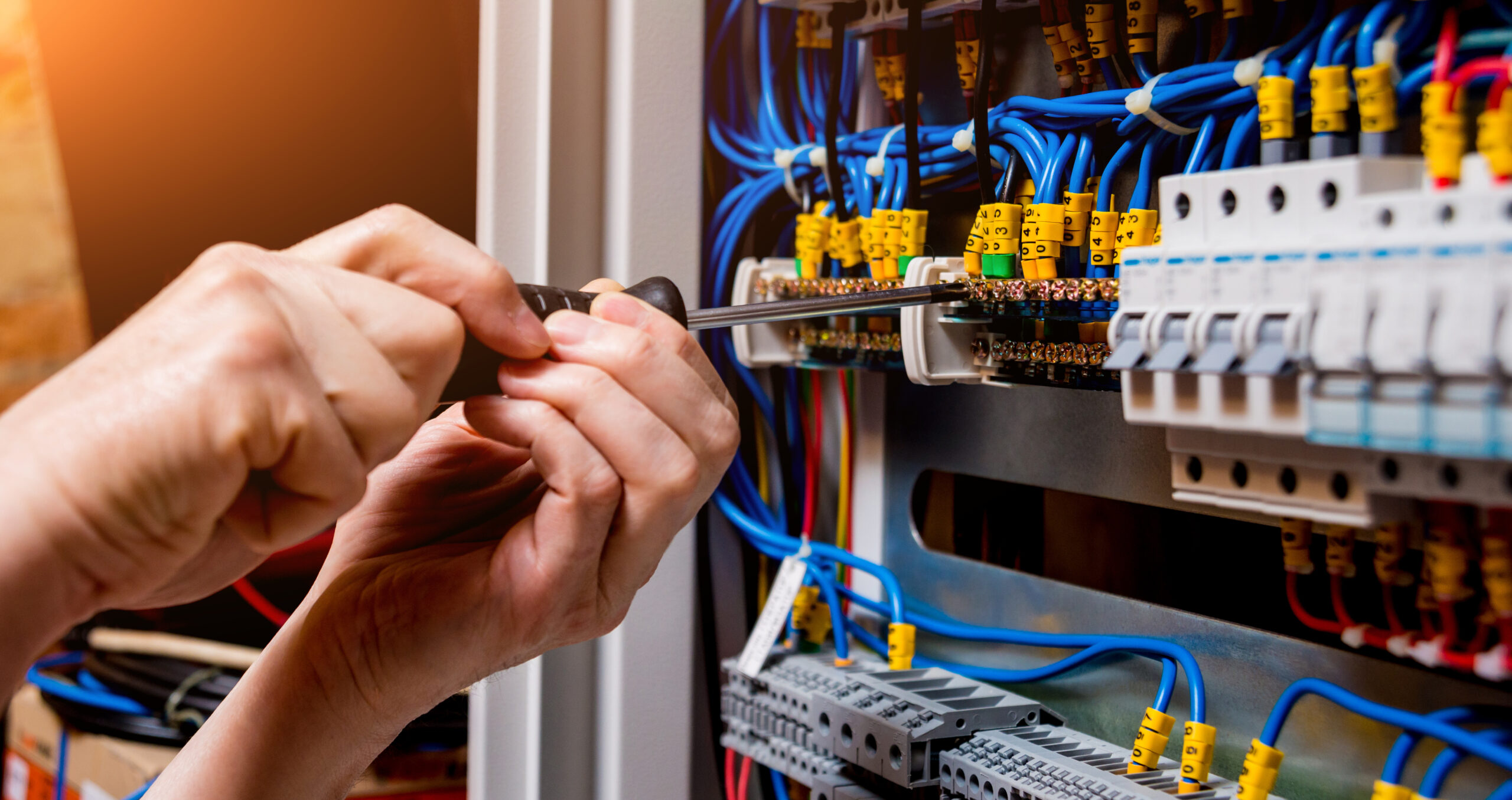 An electrician repairing a switchboard as part of a commercial electrical service delivering safe and efficient electrical maintenance
