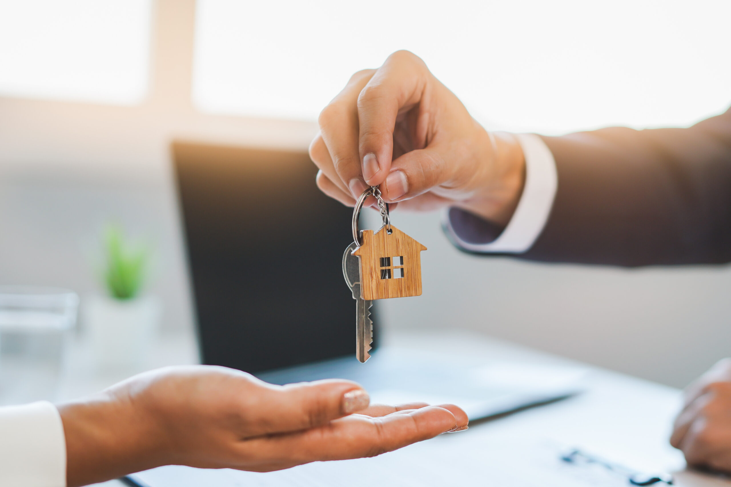 A landlord receiving property keys while arranging professional plumbing and heating services
