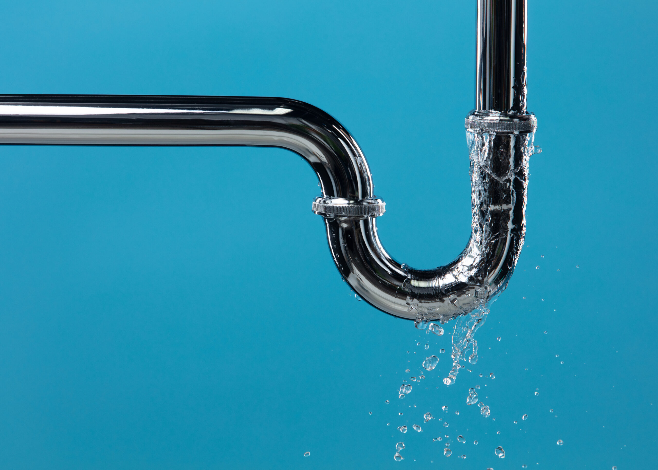 Burst pipe with active water leak highlighting professional leak detection and emergency plumbing repair services.