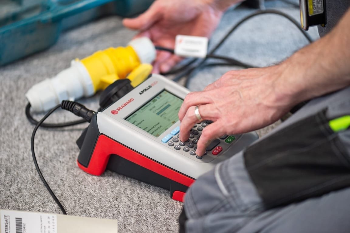 An electrician performing a Portable Appliance Testing (PAT) in accordance with safety and compliance in Scotland