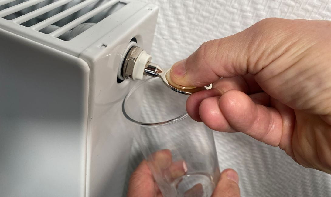 A radiator being bled during a boiler maintenance service